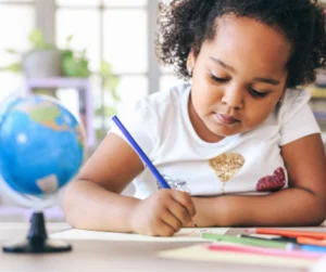 a girl writing with a tripod grip