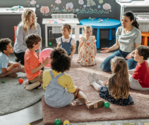 children and teachers sitting in circle time in a kindergarten classroom